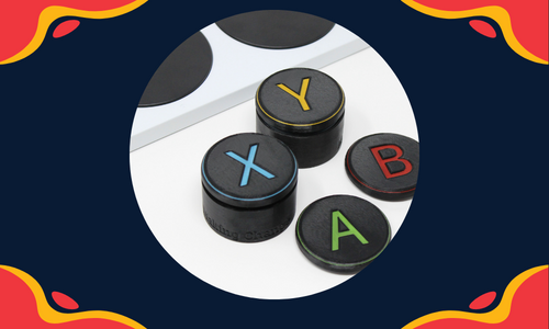 A graphic with red and yellow blobs in all 4 corners of the rectangle with a circular photo in the center showing 4 assistive switches and a corner of an Xbox Adaptive Controller.