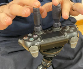 Controller on a mount with extended thumbstick toppers added on