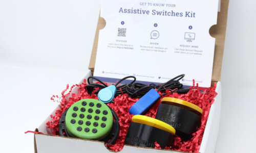 Various assistive switches in a box resting on red crinkle packing paper